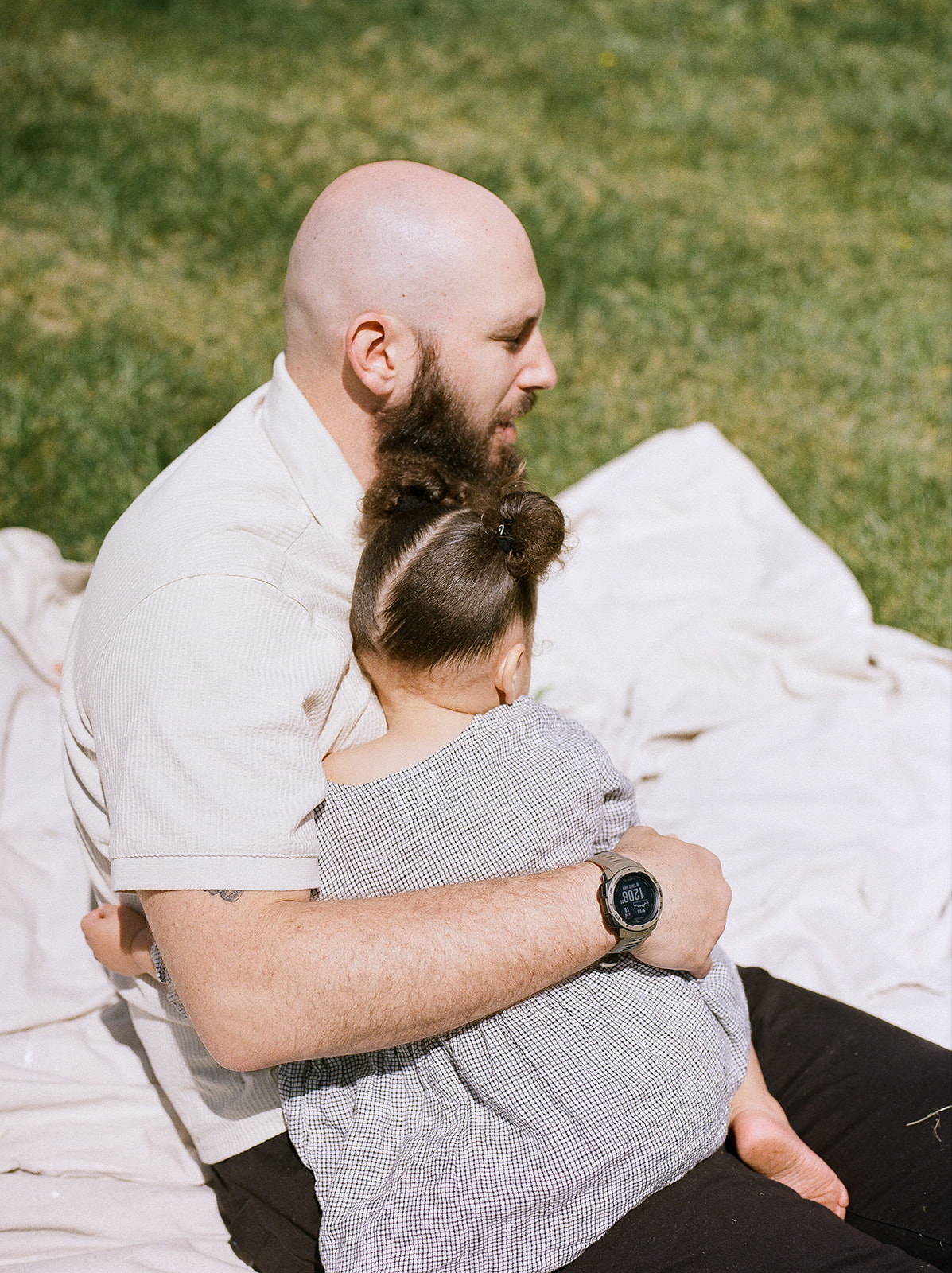 A young girl falls asleep in her father's lap
