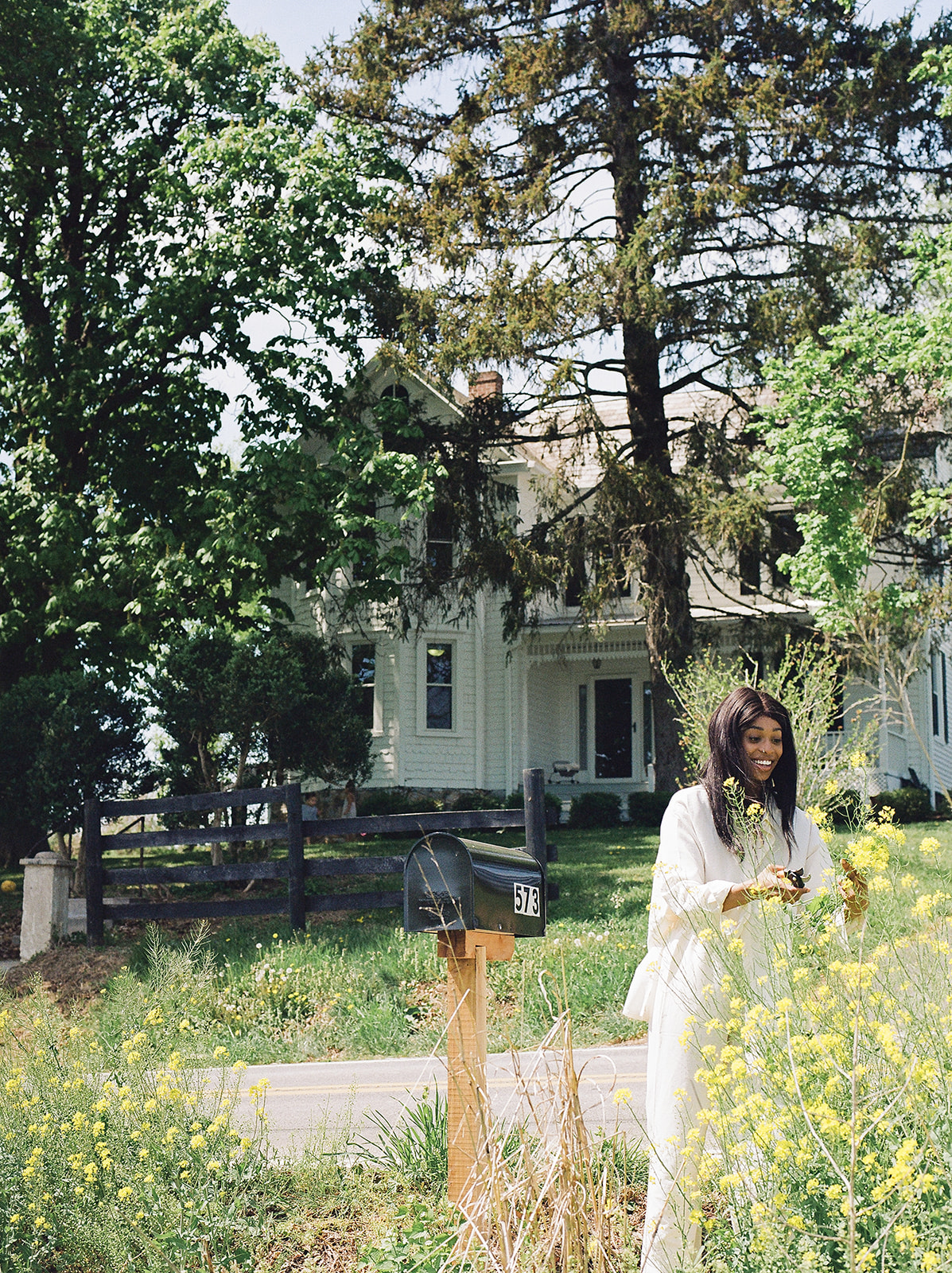 A woman cutting flowers in front of her home in West Virginia 
