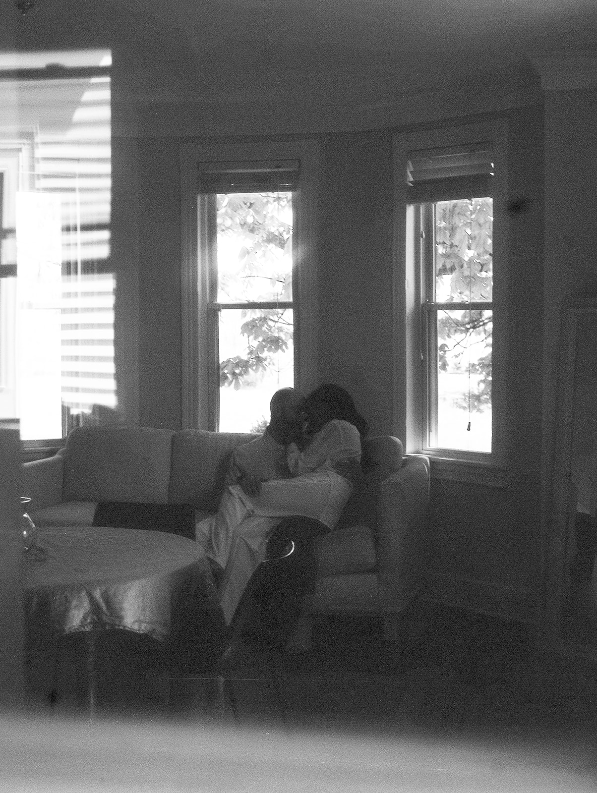 Film family photos of a man and a woman sitting in their living room 