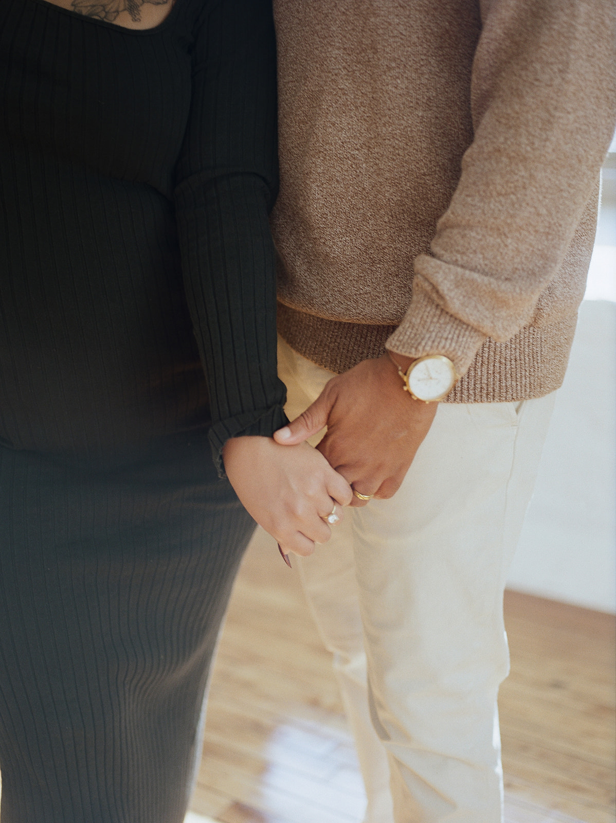 A close up film photo of a man and woman holding hands