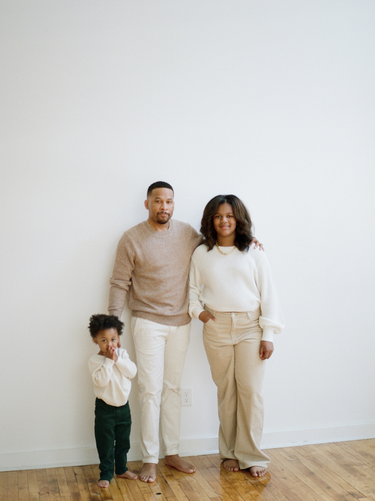 A father stands with his teenage daughter and toddler in an industrial studio in Baltimore