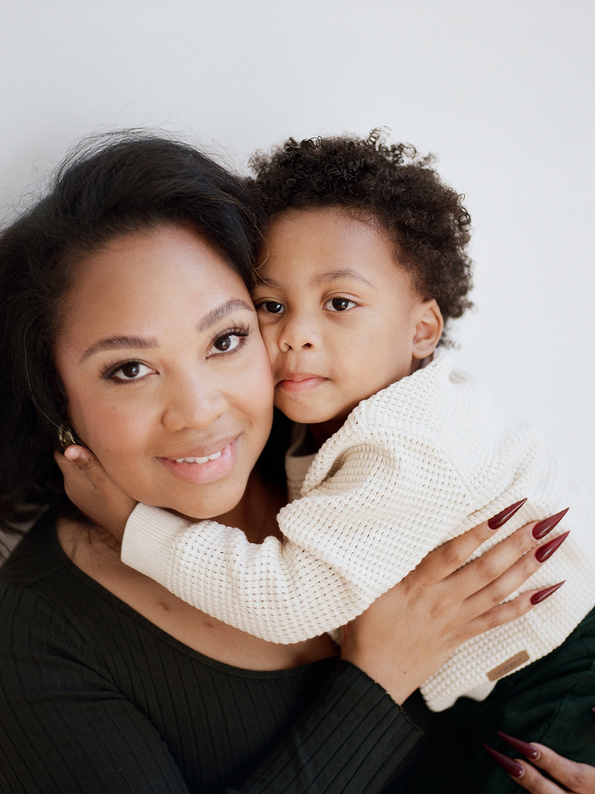 A mother and toddler smile at the camera