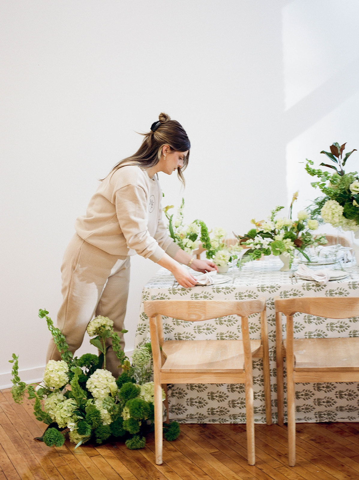 A wedding planner arranging place settings on a table
