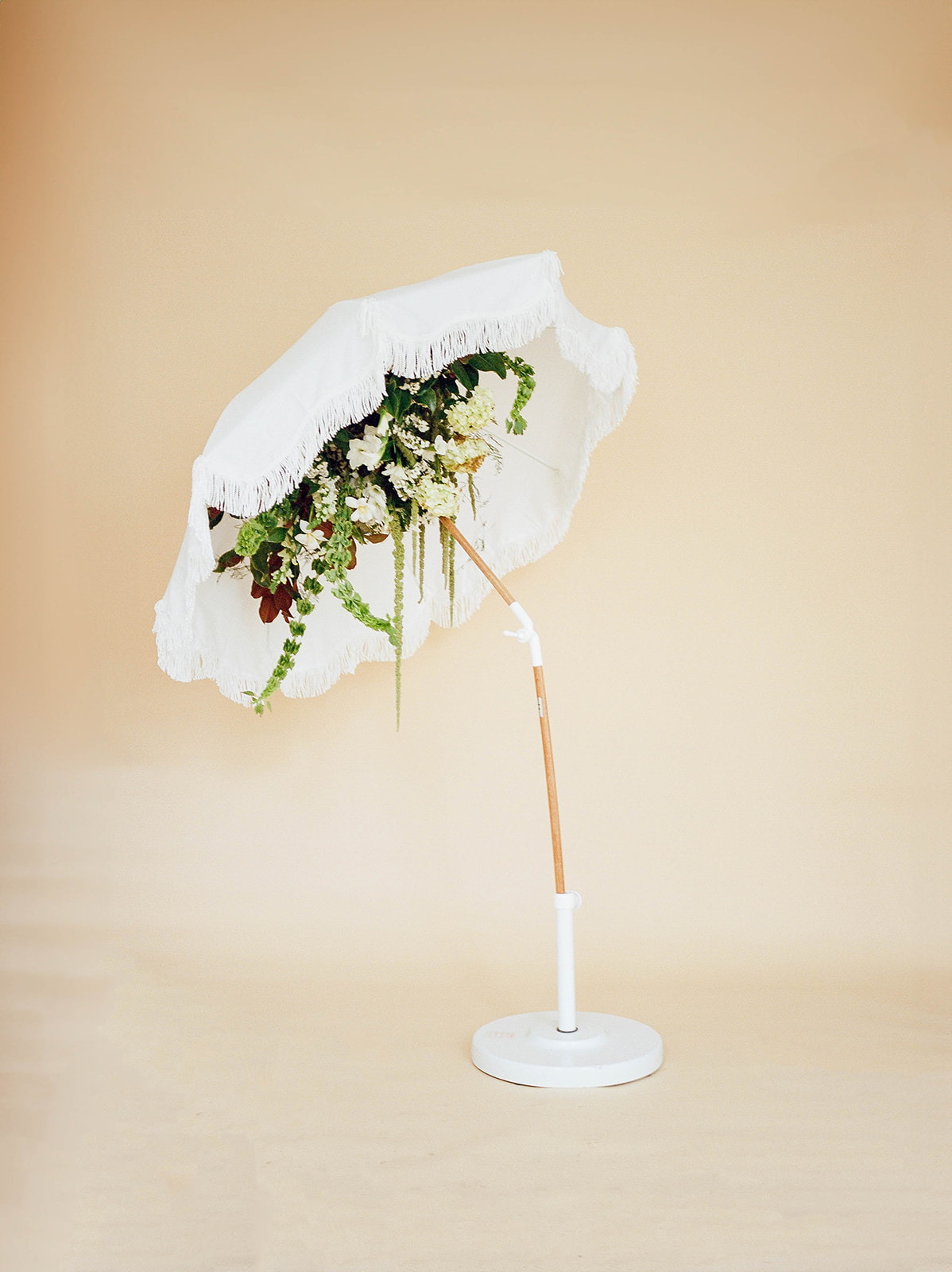 A beach umbrella with flowers underneath