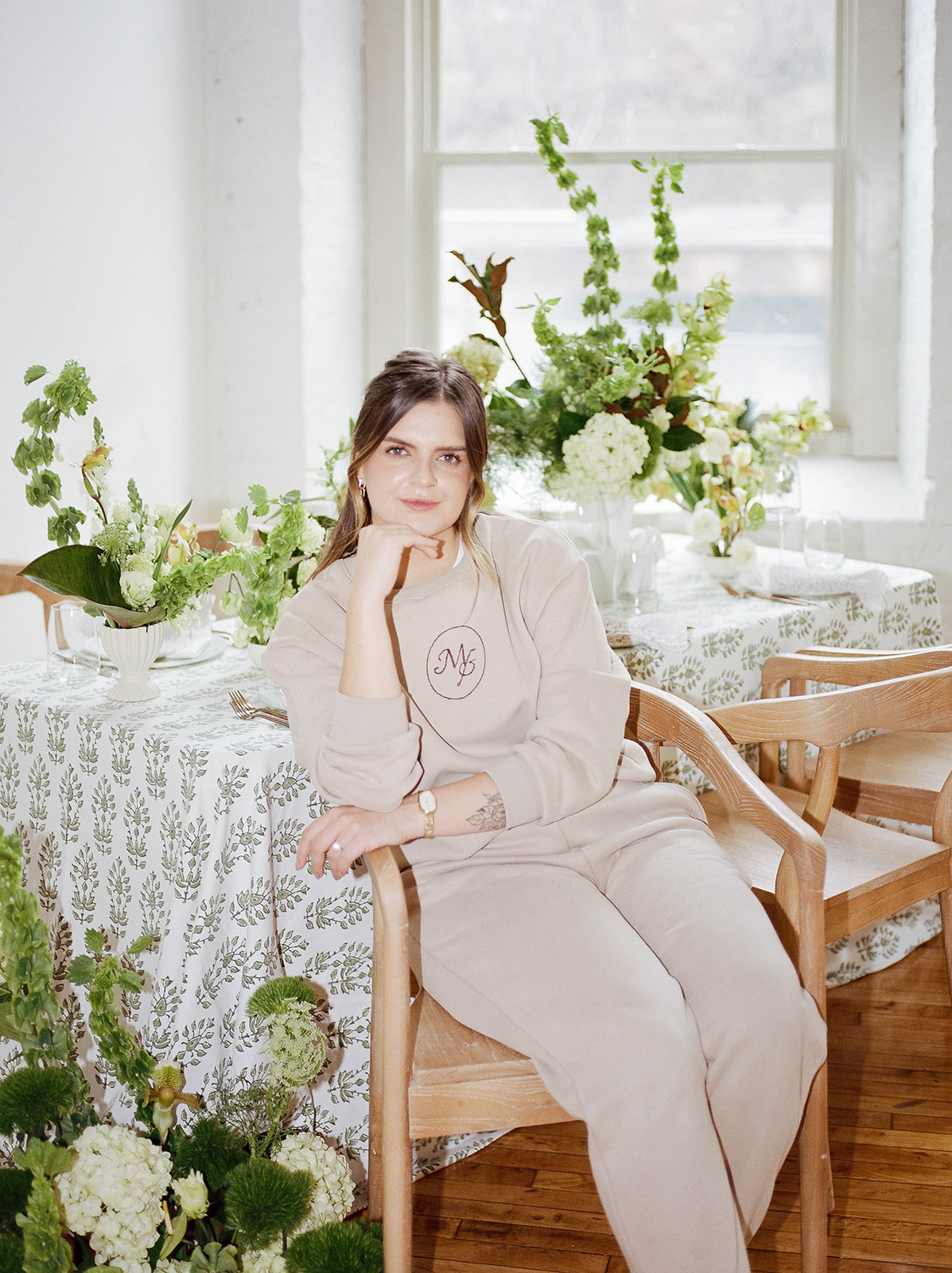 A wedding planner sits in front of a table she designed for a wedding