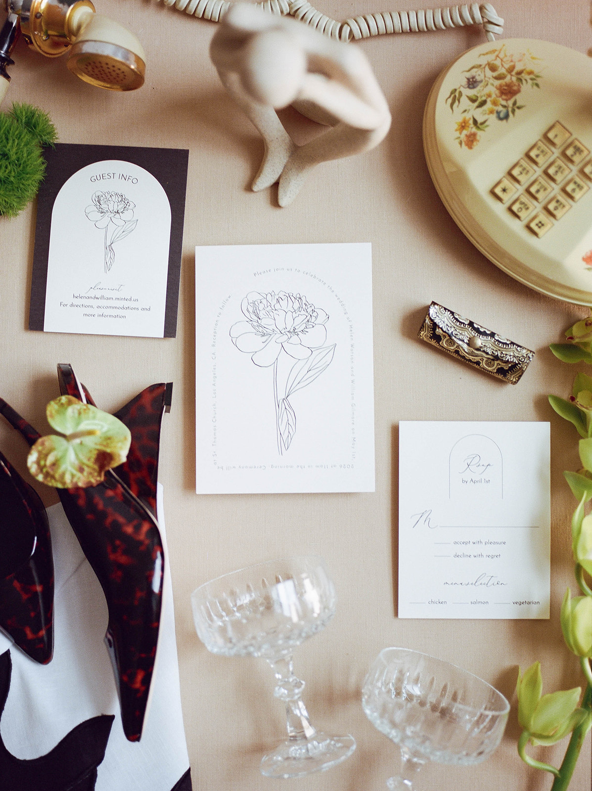 A flat lay of wedding invitations and an old phone
