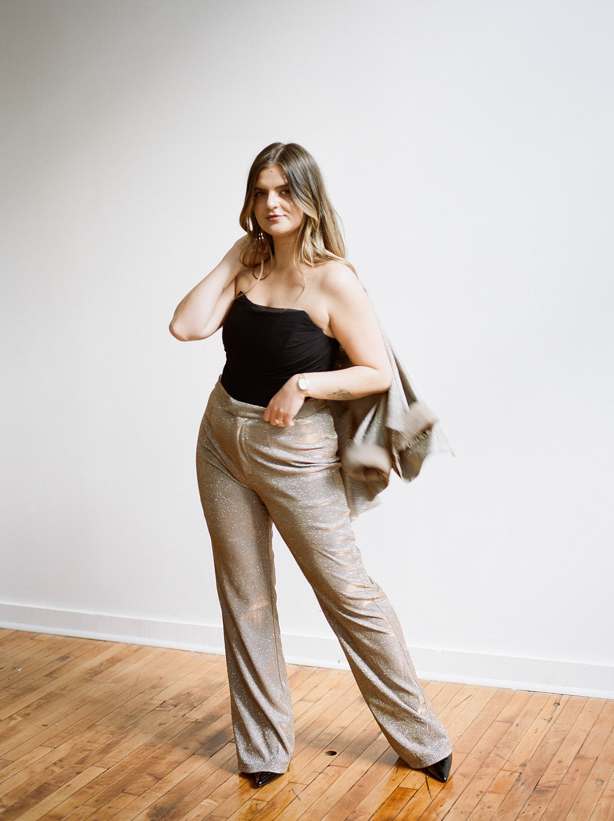 Brand photos of a wedding planner in a sparkly suit and a black strapless corset top