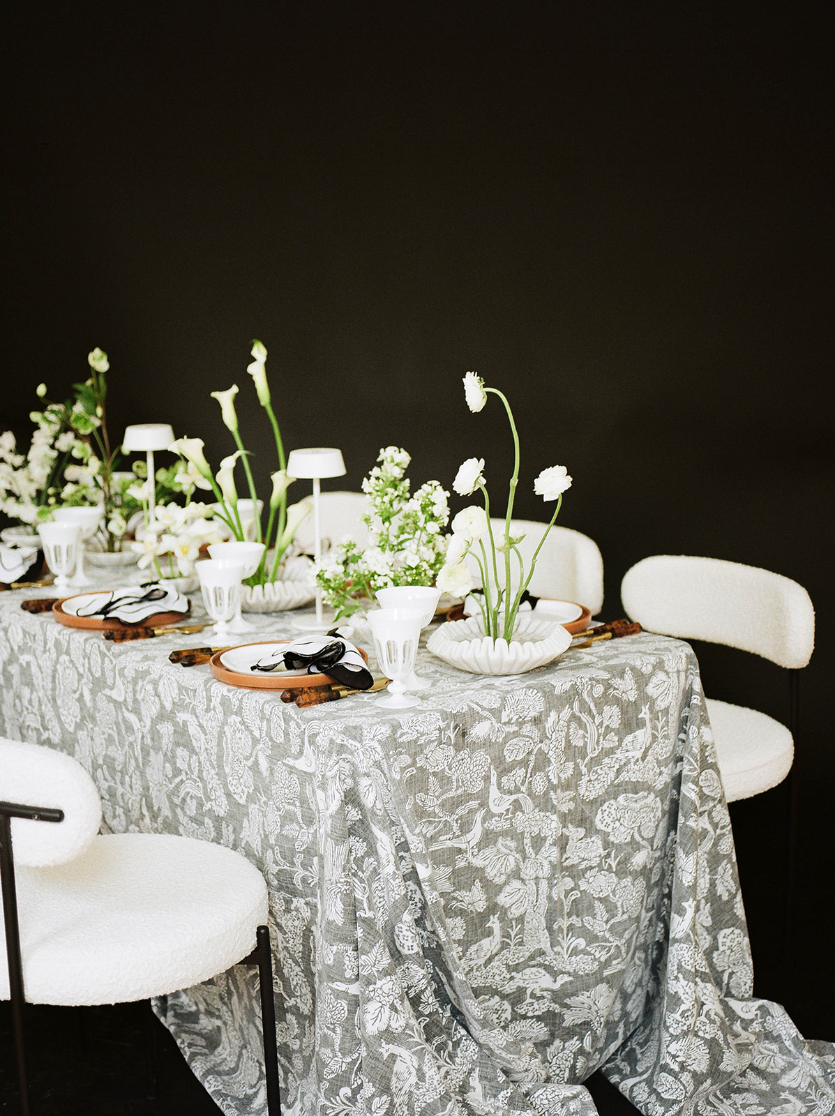 A grey tablecloth with woodland animals set by the wedding planners at Margot & Co.