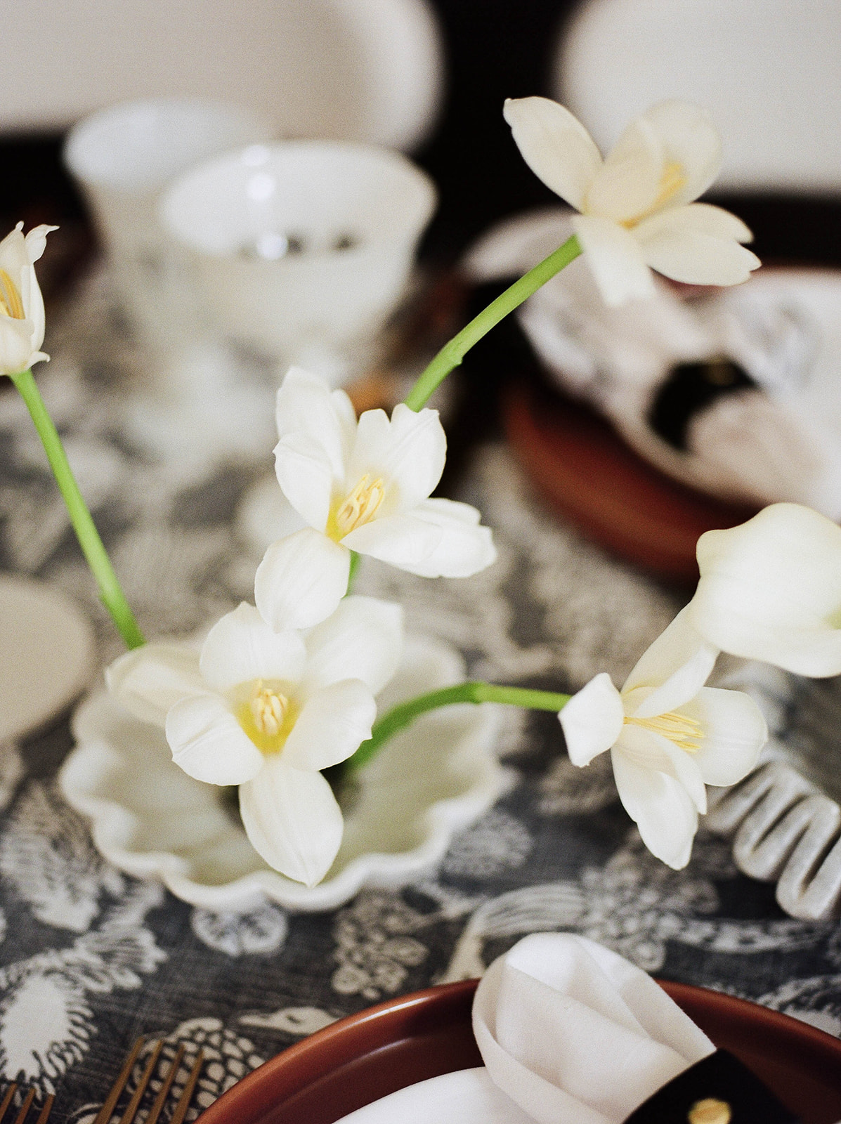 Close up film photos of small white flowers on a table set for a wedding