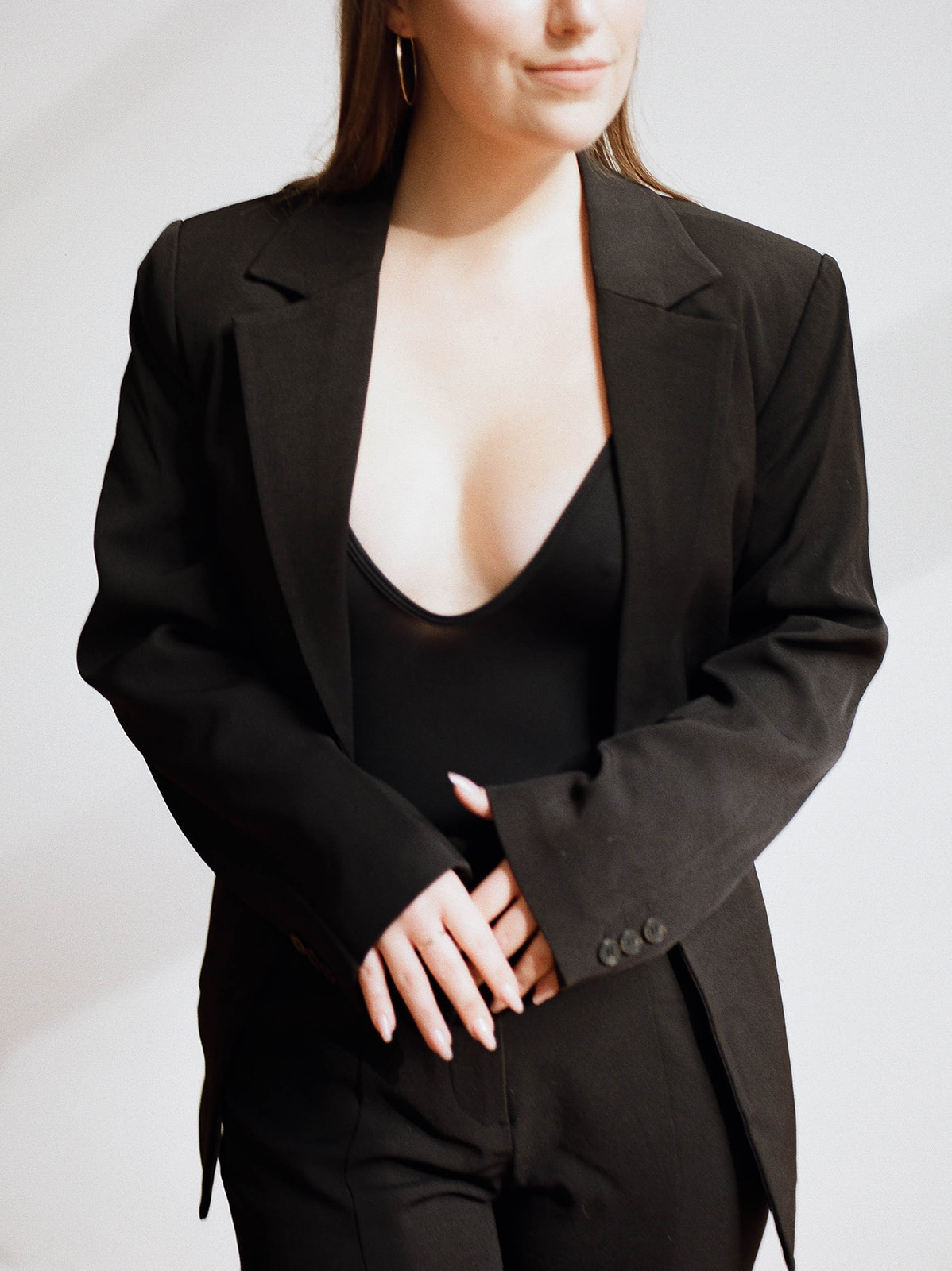 A close-up of a wedding planner in a sleek black suit in a sunlit area of a photography studio