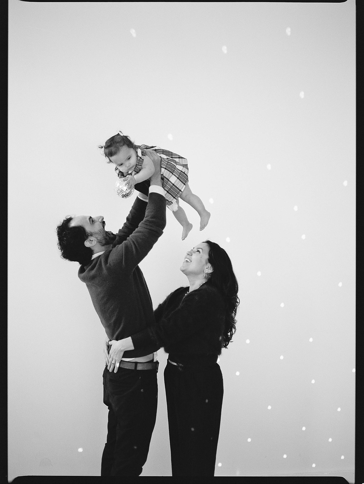 A black and white film photo of a family of three taken in a Baltimore photography studio