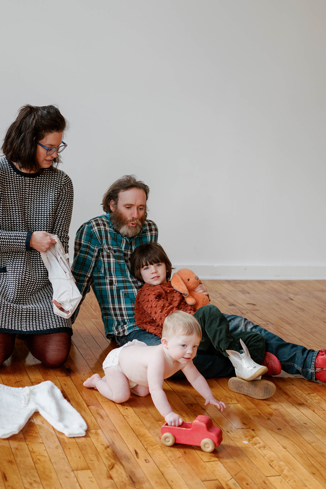 A family of four sits on the hardwood floor of a photography studio in Baltimore, Maryland