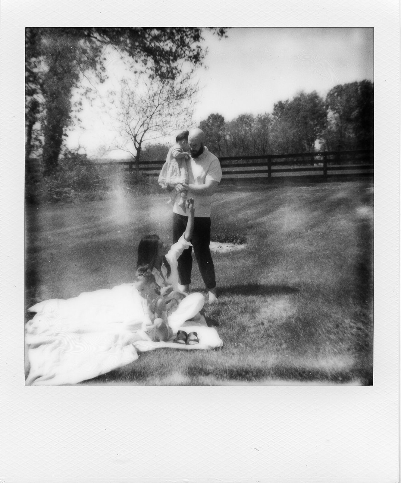 A black and white Polaroid of a family picnic
