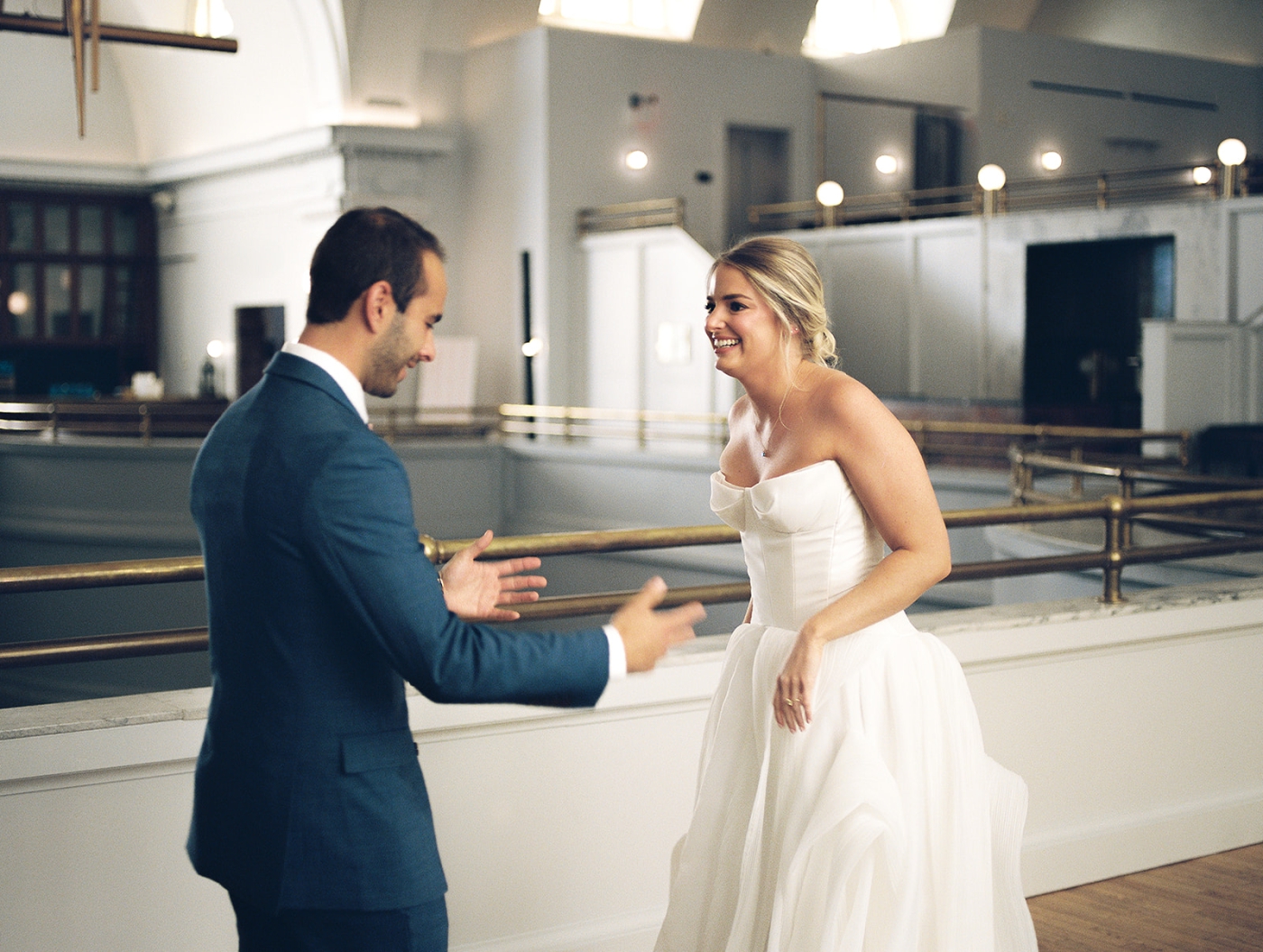 A film photo of a groom reacting to seeing his bride in her wedding dress