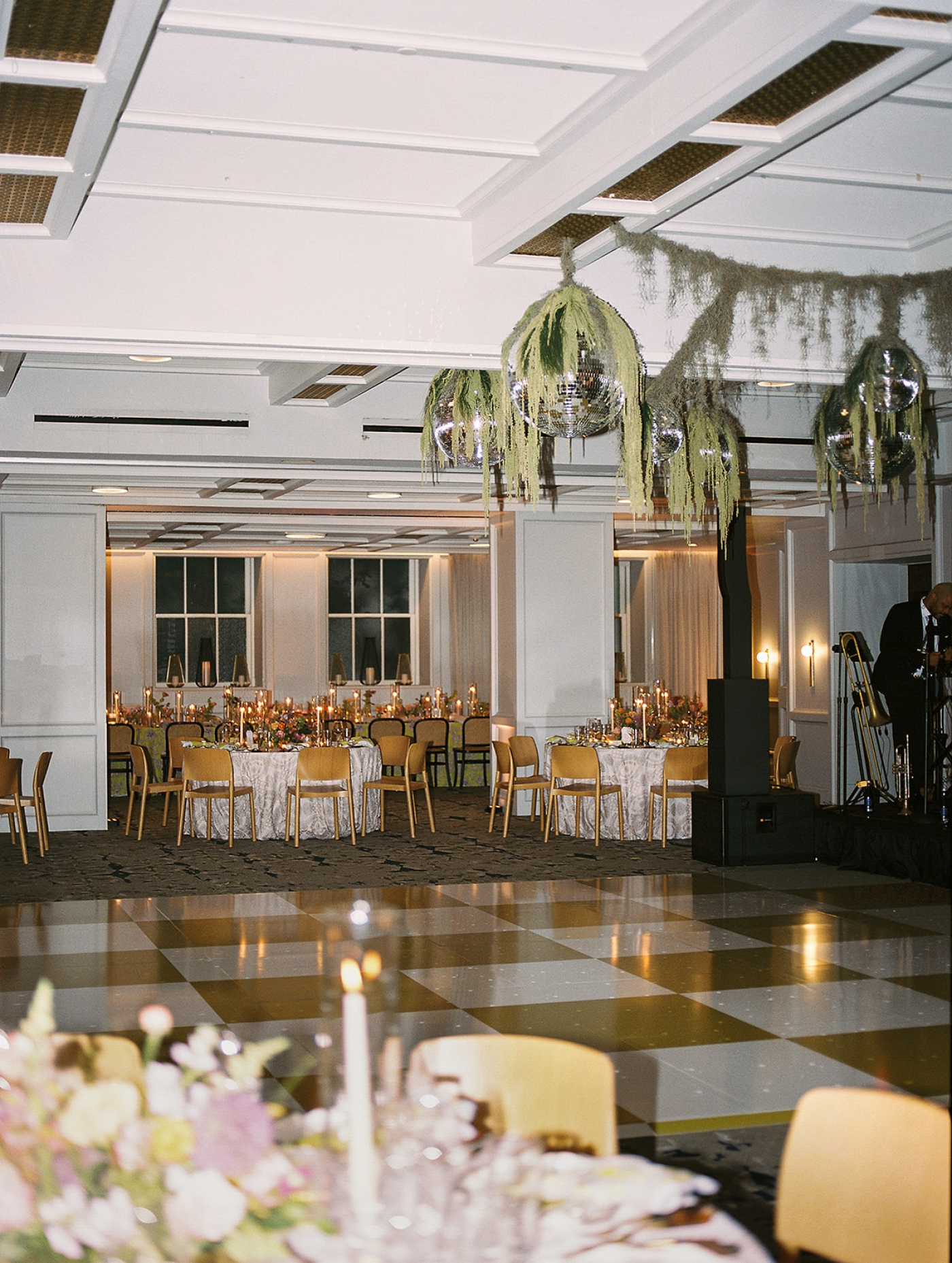A custom dance floor with disco balls covered in green vines in the Banneker Ballroom at The Line DC 