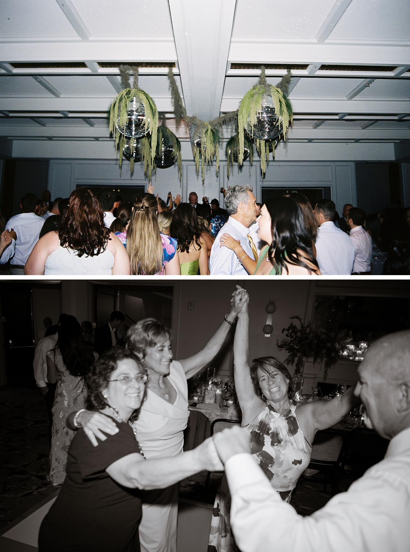 Disco balls covered in greenery hanging above a full dance floor at a wedding reception 