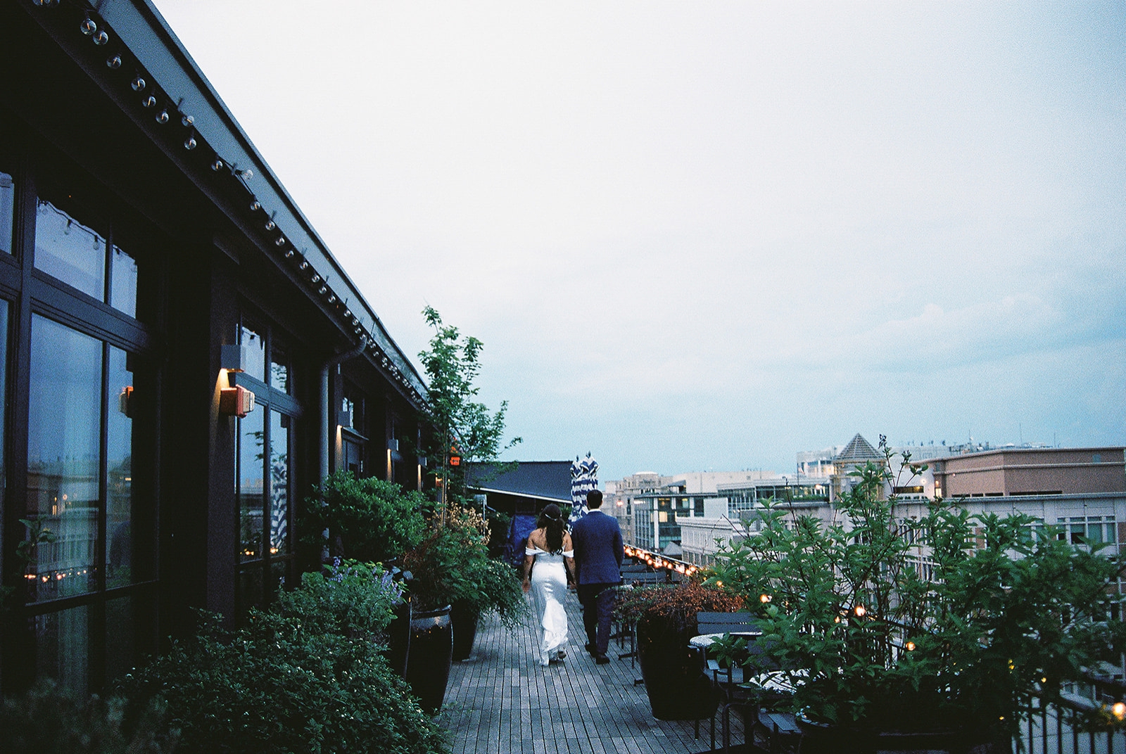 A bride and groom on the rooftop terrace of the Riggs Hotel 
