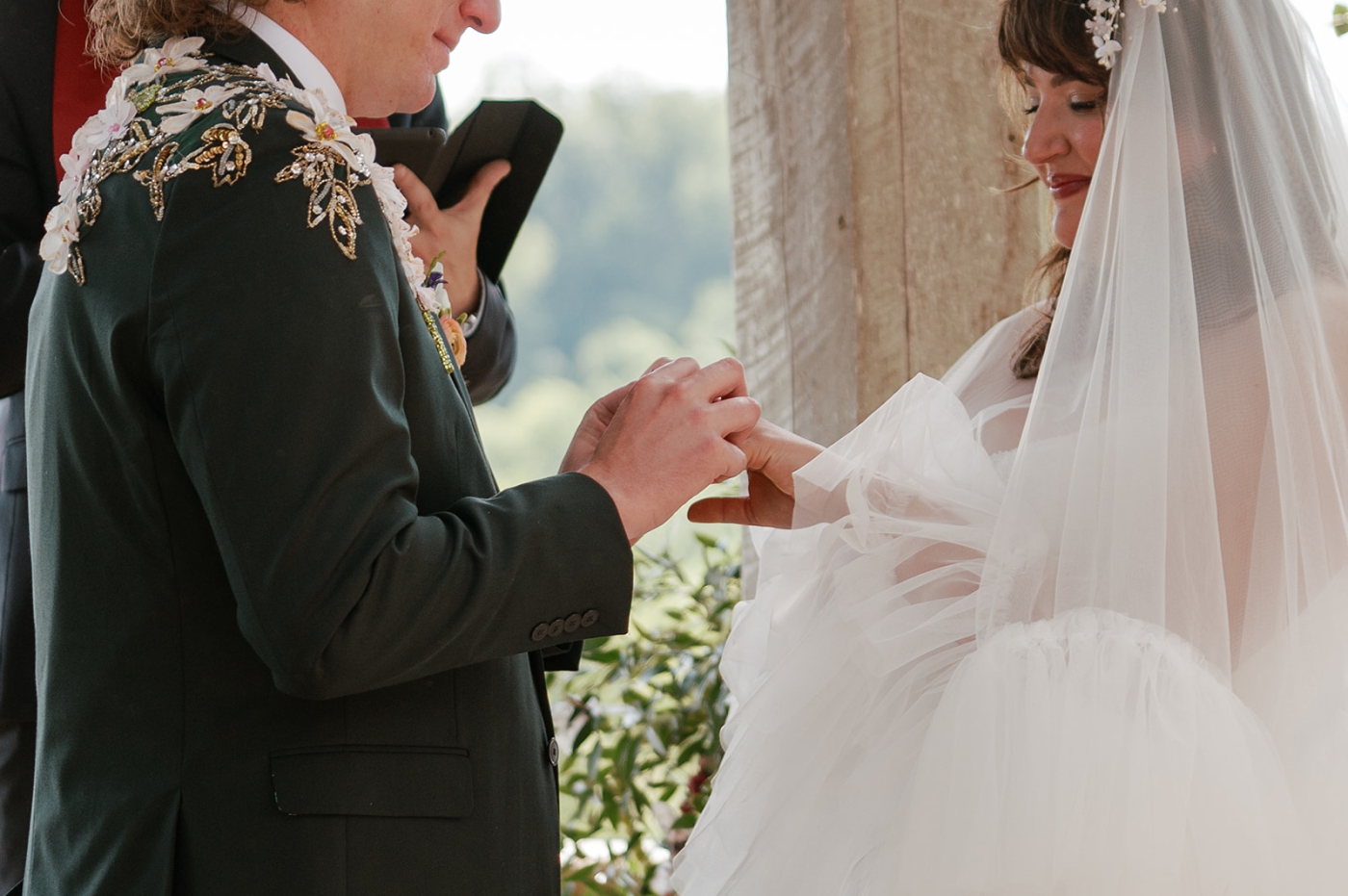 A bride and groom exchange rings beneath the gazebo at Little Oatlands