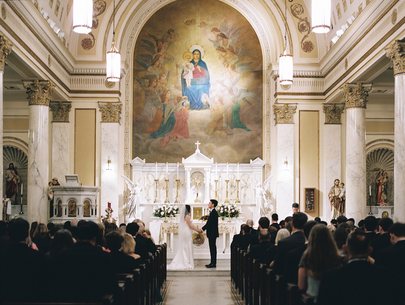 A bride and groom exchange vows during their wedding ceremony in a Catholic church