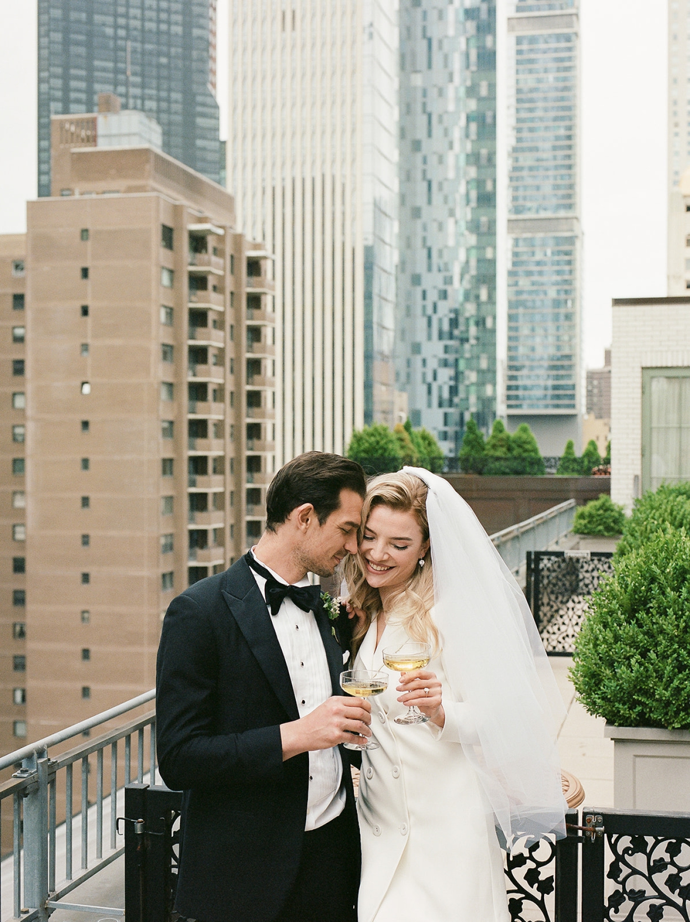 A bride and groom on the Plaza Hotel balcony in New York City