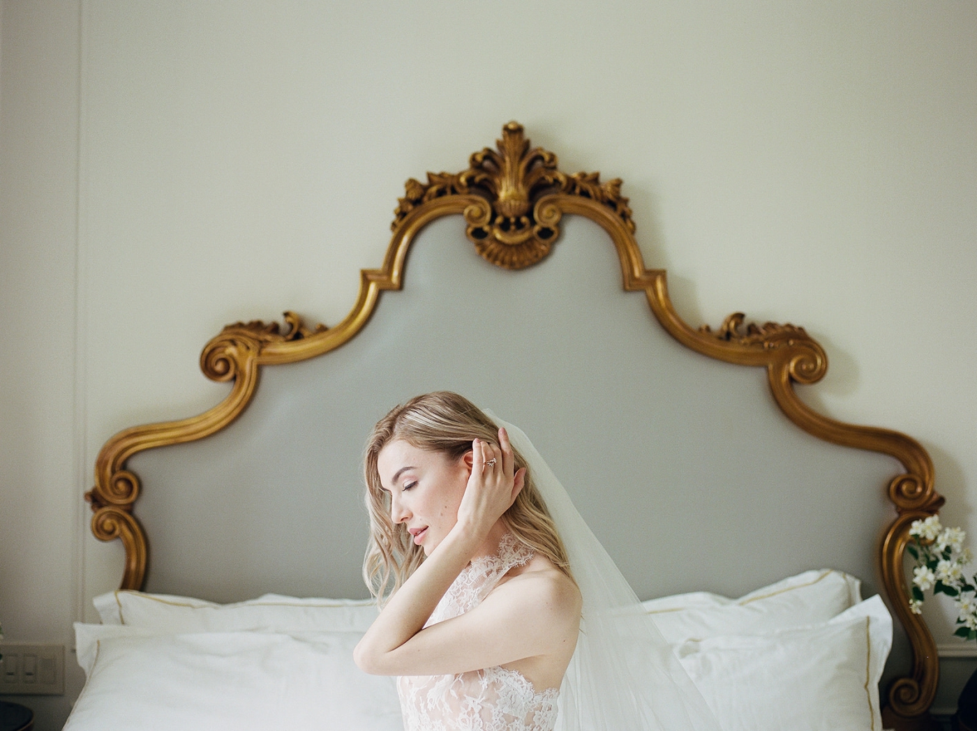 A bride sitting on a gold-gilded bed in the Plaza Hotel