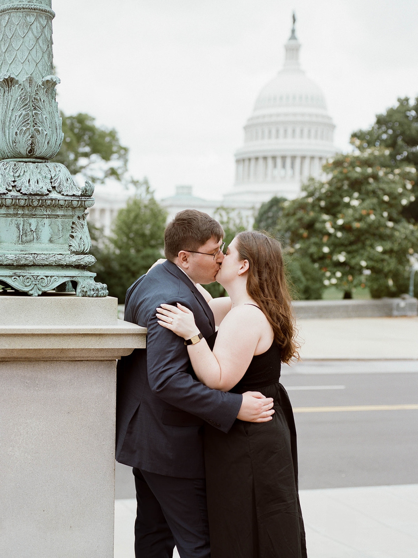 An engagement photo of a man and woman kissing in Washington, DC with the Capitol Building in the background