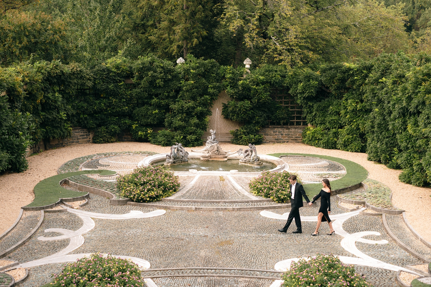A couple walks along the cobblestones at Dumbarton Oaks during their DC Engagement Session