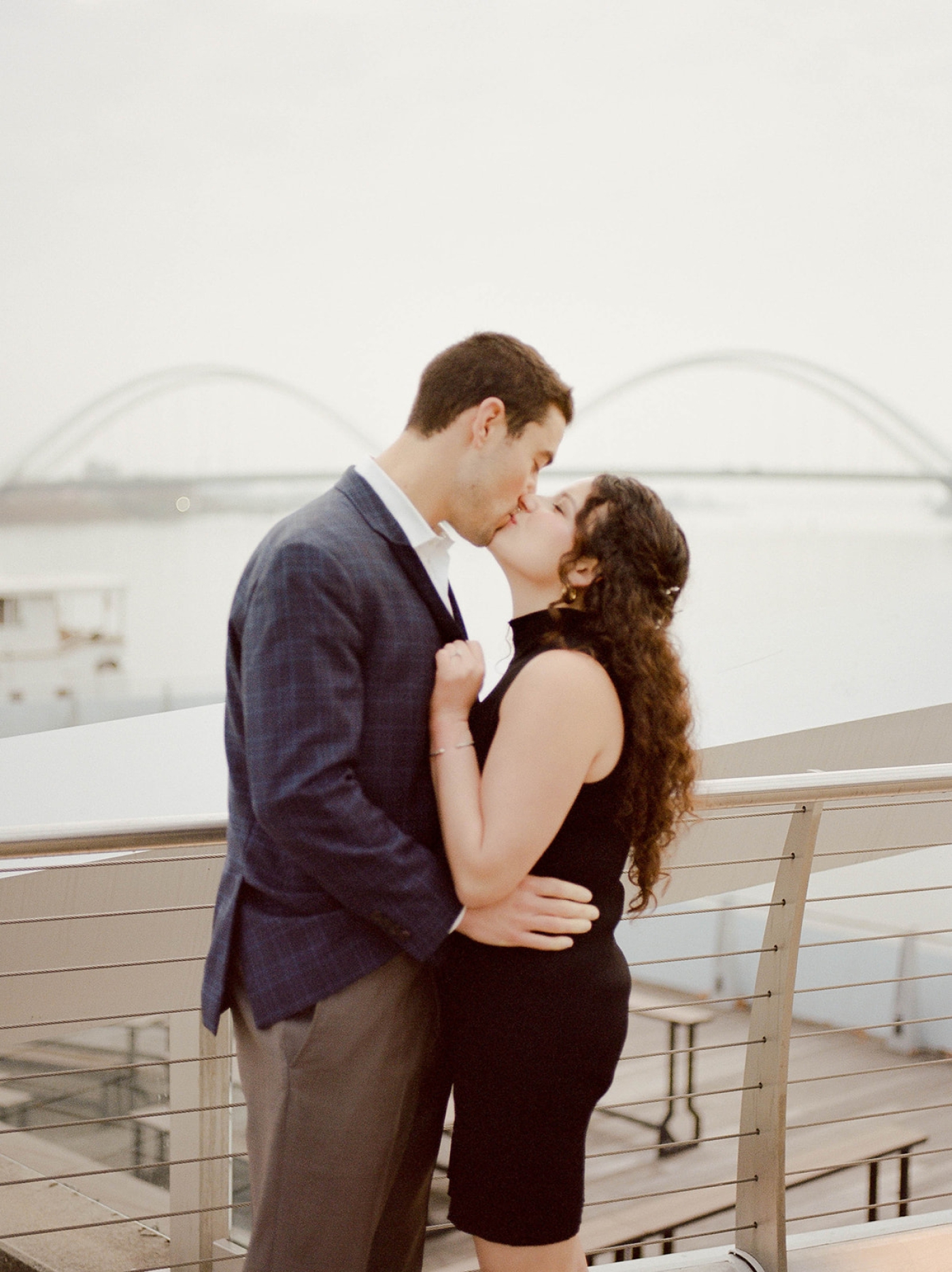 A couple kisses on a walkway overlooking the water in Washington DC 