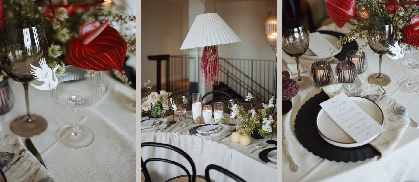 A wedding reception table with black dishes, linen napkins, and wine glasses with heron-shaped name place cards