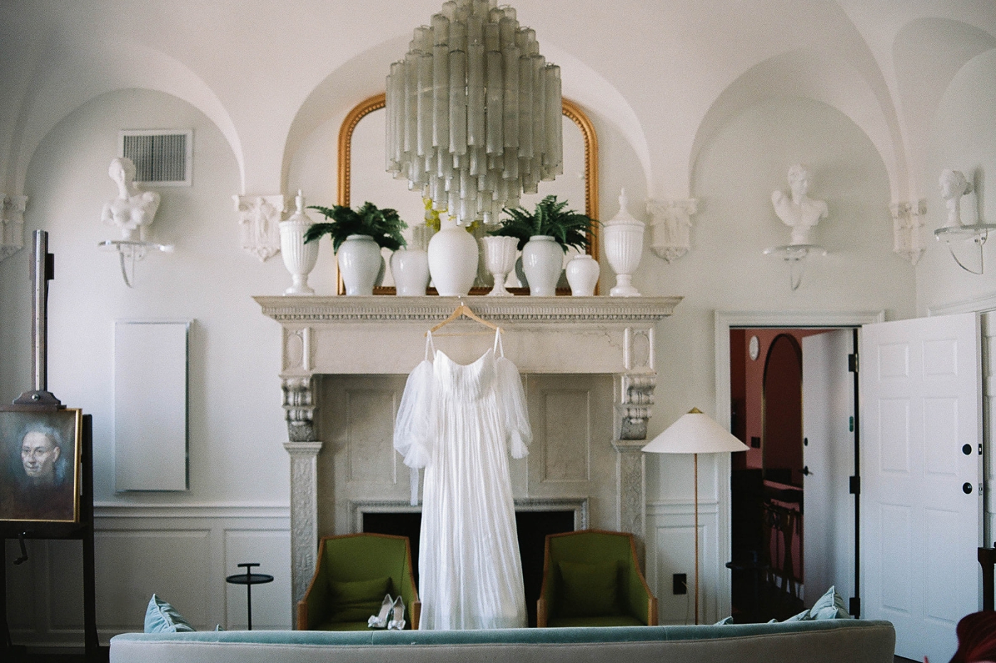 A wedding dress with Detatchable sleeves hanging from the mantle in a suite at the Riggs Hotel 