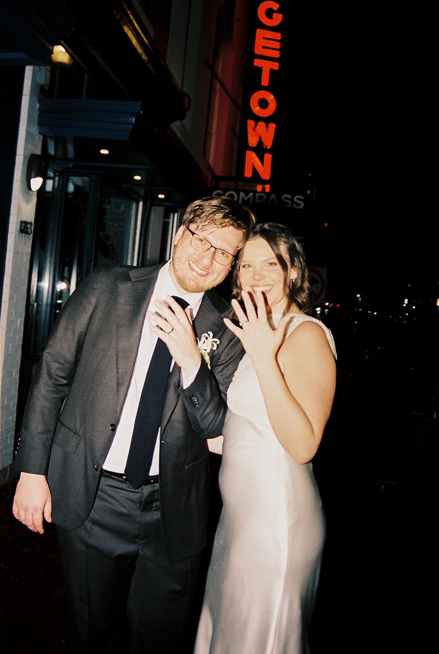 A bride and groom showing off their wedding rings outside the Fathom Gallery in Georgetown