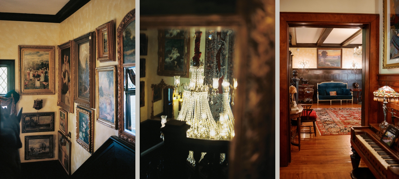 Inside the Grammercy Mansion, with antique chandeliers, an upright piano, and a staircase lined with oil paintings in gold frames