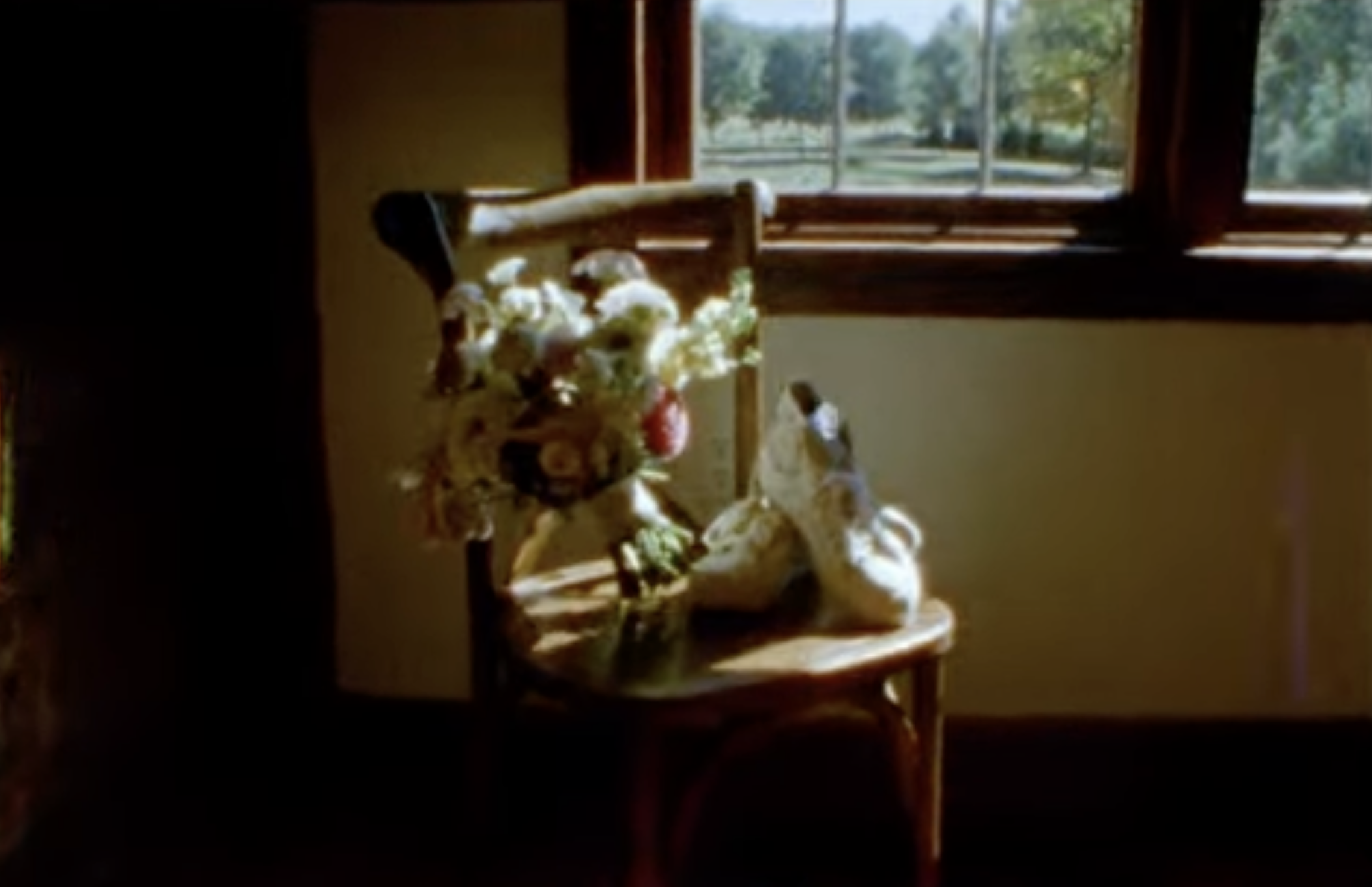 A screenshot from a Super 8 film of shoes and a bridal bouquet