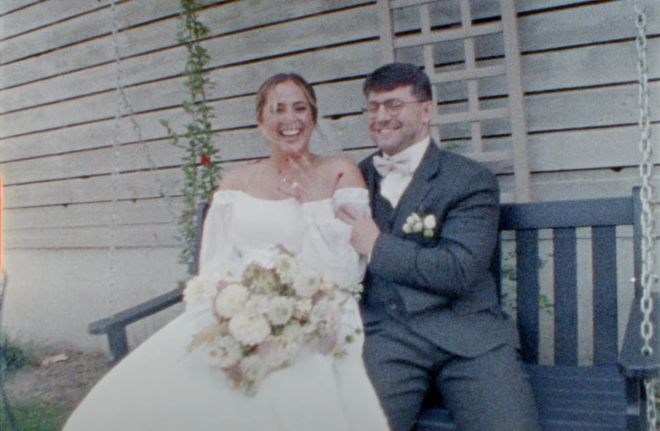 A bride and groom sitting on a porch swing after their wedding ceremony 