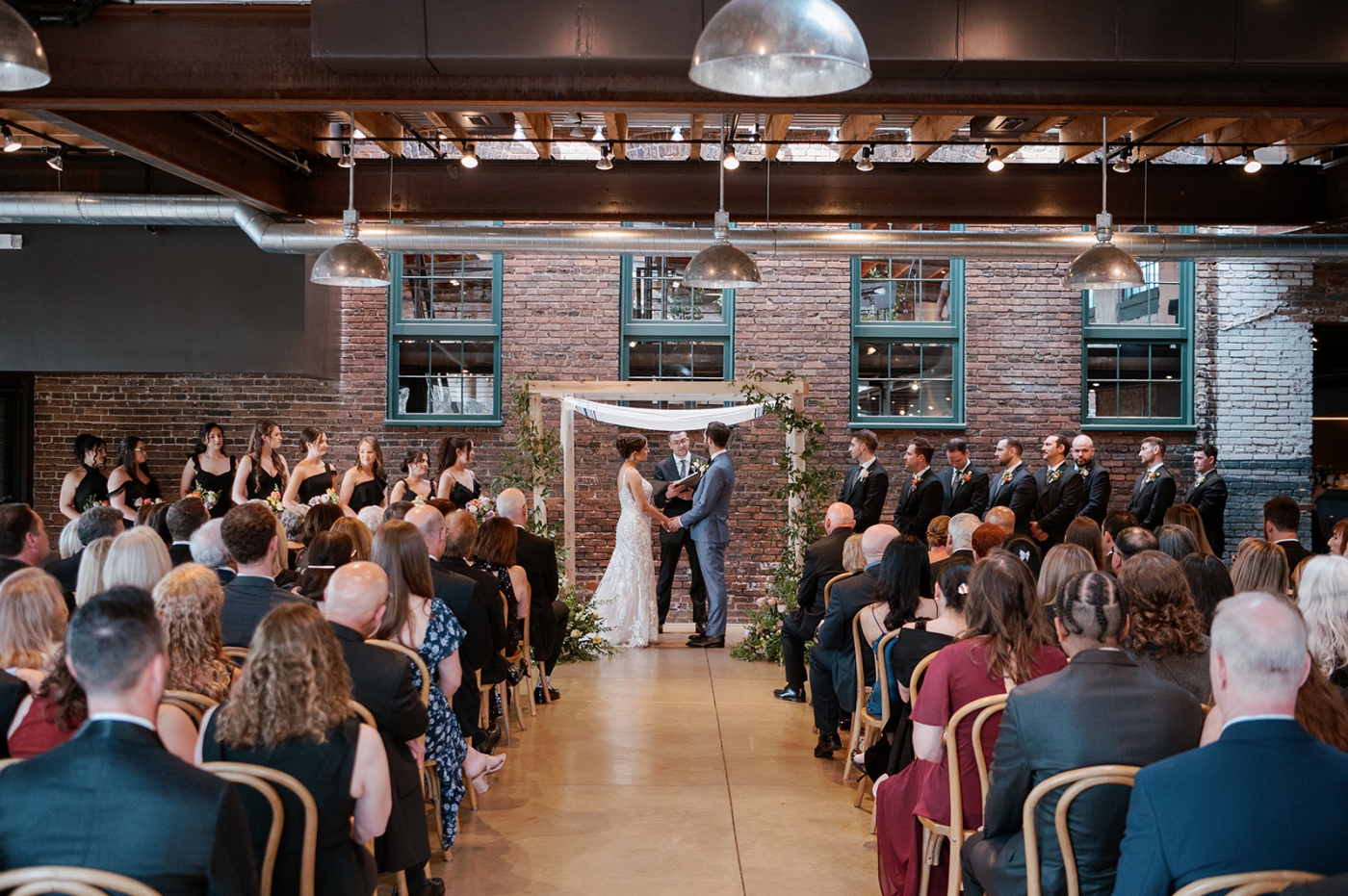 A bride and groom exchange vows beneath a chuppah