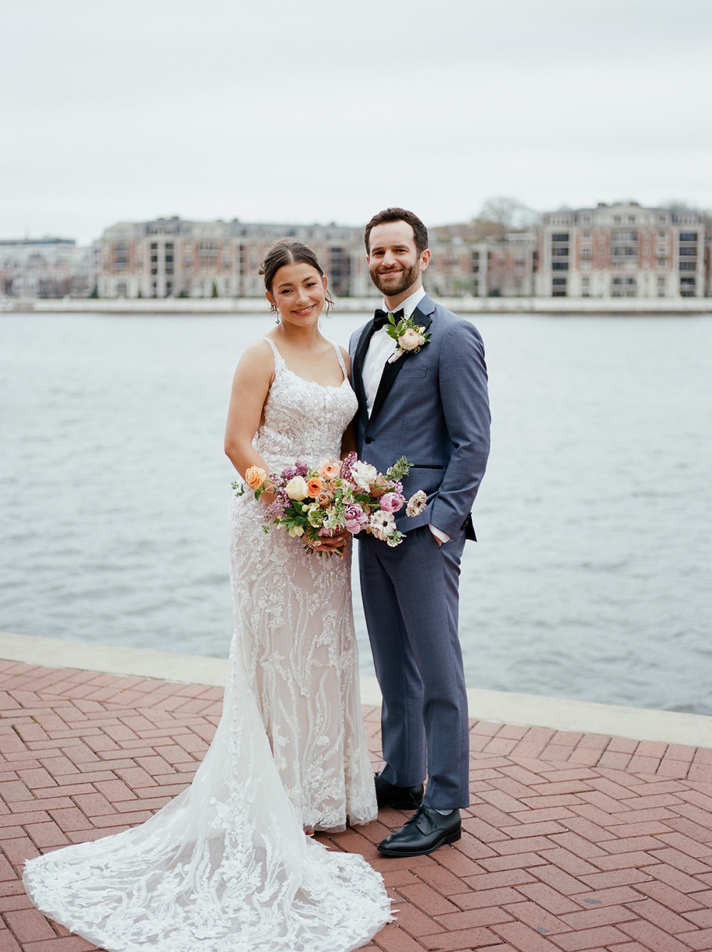 A bride and groom stand along the Inner Harbor in Baltimore